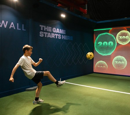 A boy kicking a ball enjoying X-Wall Interactive Football